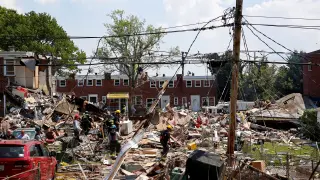 Rescue workers stand on the debris of a destroyed building after an explosion in a residential area of Baltimore, Maryland, U.S. August 10, 2020. REUTERS/Rosem Morton [[[REUTERS VOCENTO]]] USA-BALTIMORE/BLAST