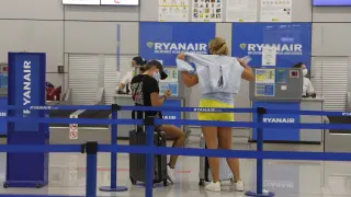 Dos jóvenes esperan a hacer el check in en la compañía Ryanair, este martes en el aeropuerto de Palma de Mallorca.