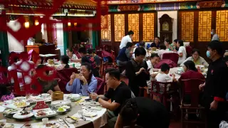 ente cenando en un restaurante de Pekín, este martes.