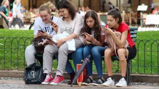 Grupo de adolescentes mirando el móvil.