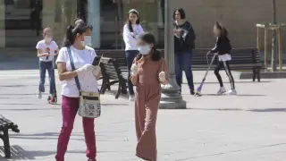 Una niña paseando por las calles de Huesca con mascarilla