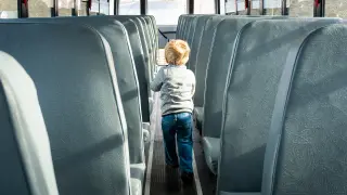 Un niño en el interior de un autobús escolar. Transporte escolar. Recurso.