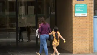Una niña, acompañada por una adulta, accede ayer a un centro de salud de Zaragoza.