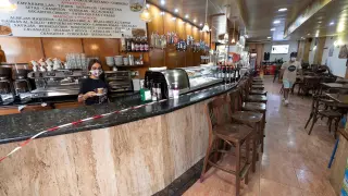 Imagen de archivo de una camarera trabaja tras una barra de bar precintada.