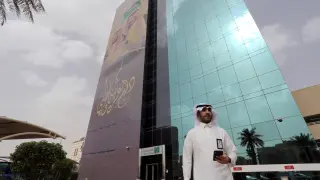 Un hombre pasa delante de la sede del Banco Comercial Nacional de Arabia Saudí, en Ryad.