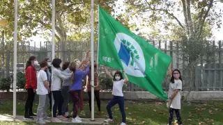 Los alumnos izan la bandera que les acredita como Eco Escuela