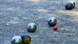 la petanca es un juego tradicional en el que el objetivo es lanzar bolas metálicas tan cerca como sea posible de una pequeña bola de madera