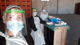 Dos rastreadoras y el coordinador médico del Centro de Salud de Fuentes de Ebro hacen PCR con los EPI en una finca de Pina, este verano.