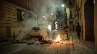 Un joven coloca una barricada en una calle de Barcelona.