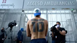 A fan of Argentine soccer great Diego Maradona stands outside the clinic where he will be undergoing surgery for a subdural haematoma, according to his personal physician, in Olivos
