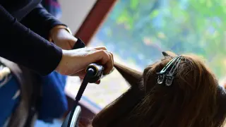 Imagen de una peluquera peinando a una clienta.