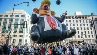 Un globo de una caricatura de Trump es aupado por seguidores de Biden en una manifestación en Washington tras las elecciones