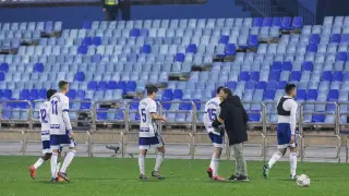 Los jugadores del Real Zaragoza se retiran cabizbajos y desolados tras perder en La Romareda por enésima vez, en esta ocasión ante el Oviedo por 1-2.