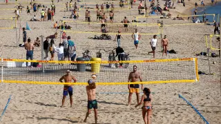 Gente jugando al voley-playa, este sábado, en la playa de la Barceloneta.