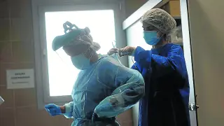 Las médicos de la unidad de hospitalización del centro covid de Casetas, María Jesús Esquillor y Rebeca Marinas, se ponen los equipos de protección individual