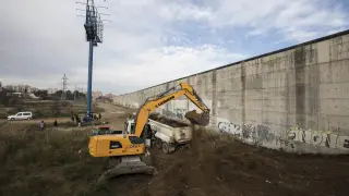 Una máquina excavadora ejecuta las labores de desbroce del terreno en el primer día de obras de la prolongación de Tenor Fleta.