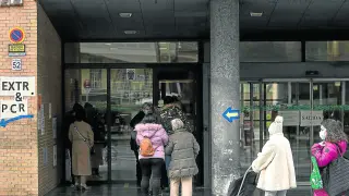 Varias personas esperan su turno para entrar al centro de salud de Sagasta, en Zaragoza.