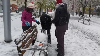 Un grupo de amigos prepara un muñeco de nieve en Gran Vía.