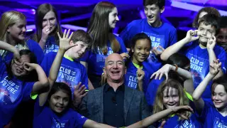 FILE PHOTO: Founder, Chairman, CEO and President of Amazon Jeff Bezos poses with children from 'Club for the Future' after his space company Blue Origin's space exploration lunar lander rocket called Blue Moon was unveil