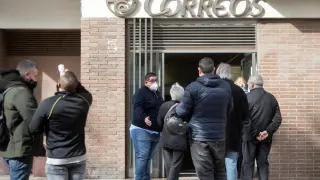 Fila en una oficina de Correos de Barcelona para pedir el voto por correo el último día de plazo.