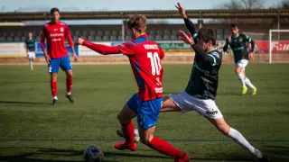 Vidorreta conduce el balón ante la presión de un jugador del equipo rival.