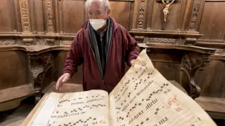Aurelio Ricou, párroco de Roda, hojeando las páginas de unos antiguos códices de la catedral.