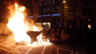 Varias personas queman contenedores en una manifestación contra la encarcelación de Hasel, en Barcelona.