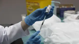 Extracción del líquido del vial para proceder a vacunar.