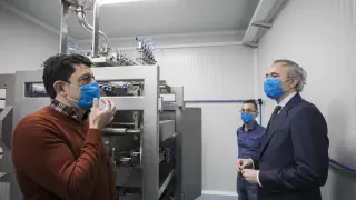 Antonio Domínguez, director técnico de Making Mask, explica al alcalde de Zaragoza Jorge Azcón el funcionamiento de la nueva máquina que producirá monodosis de gel hidroalcohólico.