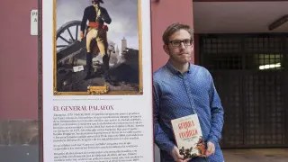 El historiador zaragozano Daniel Aquillué, con su libro recién publicado, ante la Casa Palafox