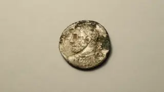 Una de las monedas encontradas en el yacimiento de Azaila, en Teruel.