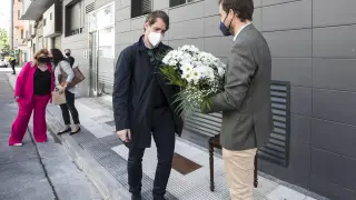 Borja Giménez, con un ramo de flores, y su hermano Manuel, ante la palca que recuerda el asesinato de su padre en la calle Cortes de Aragón el 6 de mayo de 2001.