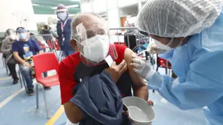 Un hombre es vacunado en Lima.