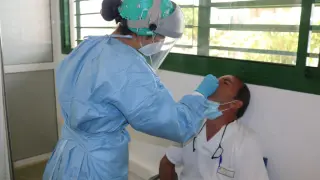 Una enfermera realiza una PCR a un sanitario en Canarias.