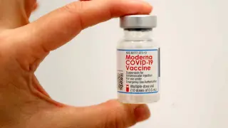 Un trabajador sostiene un frasco de la vacuna Moderna contra la covid-19