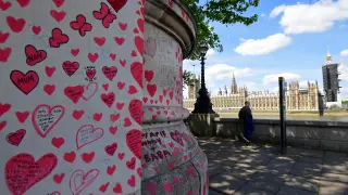 Dedicatorias a las víctimas del covid en el National Covid Memorial Wall en Londres, con el Parlamento al fondo