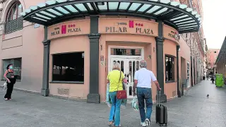 Dos turistas llegan, este jueves por la tarde, al hotel Pilar Plaza, situado enfrente de la basílica.