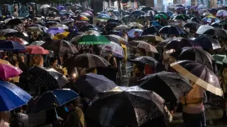 Cientos de personas se han concentrado este viernes en la plaza del Pilar de Zaragoza pese a la intensa lluvia.