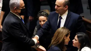 Head of Oposition Benjamin Netanyahu and Israel Prime minister Naftali Bennett shake hands following the vote on the new coalition at the Knesset, Israel's parliament, in Jerusalem