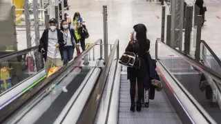 Pasajeros con mascarillas en las instalaciones del aeropuerto de Barajas.