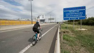 Un ciclista circula junto al lugar donde se produjo el atropello del menor de 15 años en la A-68, a la altura de La Cartuja.