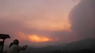 Dos personas observan la evolución del fuego en las montañas de Chipre.