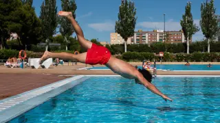 Un bañista se lanza de cabeza al agua en las piscinas del Actur, este jueves.