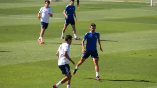 Zapater lleva la pelota ante Adrián González, ante la mirada de Iván Azón y      en el partido de entrenamiento jugado por el Real Zaragoza en la mañana de este miércoles en La Romareda.