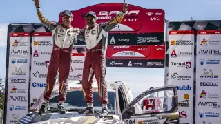 Al-Attiyah celebra el triunfo en la Baja Aragón subido en su coche con su copiloto, Baumel.