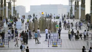 Gente alrededor de la llama olímpica en Tokio