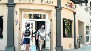 Turistas salen de un hotel del centro de Zaragoza.