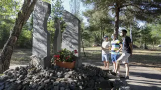 Pere Espinosa y sus dos hijos, Oriol (con camiseta azul) y Arnau (con polo de rayas), supervivientes de la riada de Biescas en la que murió la madre, este viernes en el memorial.