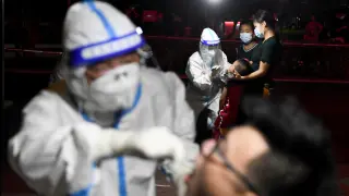 Medical workers collect swab from residents following the COVID-19 outbreak in Zhangjiajie