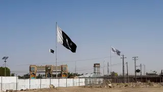 General view of the Pakistan's flag and the Taliban's flag in the background as seen from the Friendship Gate crossing point in the Pakistan-Afghanistan border town of Chaman